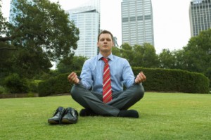 Businessman meditating in park
